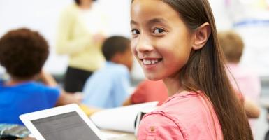 Enfant souriant avec une tablette