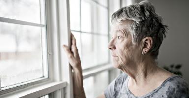 senior qui regarde par la fenêtre