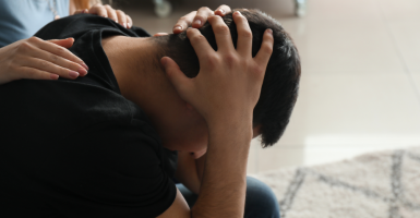Homme qui se tient la tête entre les mains