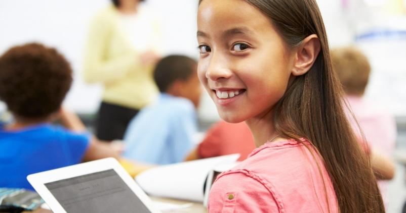 Enfant souriant avec une tablette