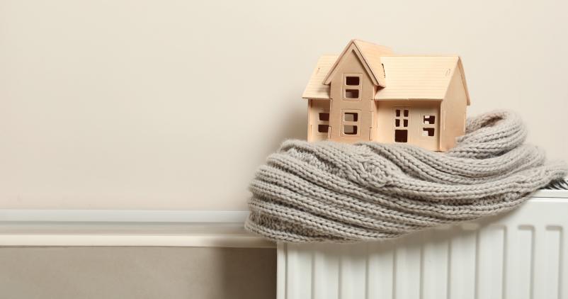 Maison en bois sur un radiateur entourée d'une écharpe