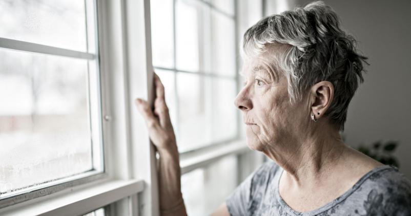 senior qui regarde par la fenêtre