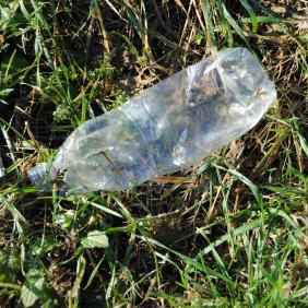 Photo d'une bouteille en plastique usagée jetée dans la nature