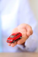 clés et petite voiture dans les mains d'une personne